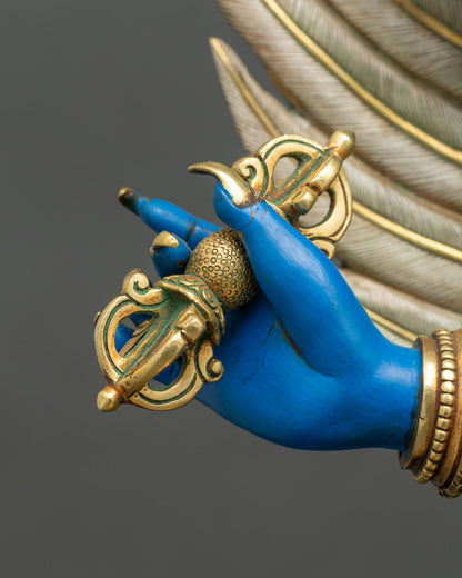 Hand of Vajrakilaya holding a gilded vajra, with silver feathered garuda wing behind