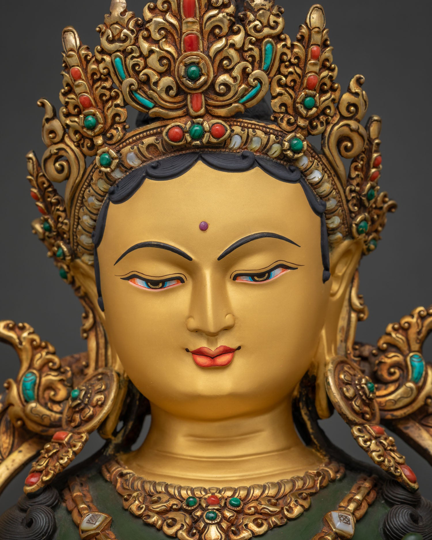 Hand-painted Green Tara face detail serene expression gold crown ornate headdress