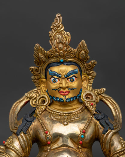 Handcrafted Dzambhala statue showing gold painted face and sacred Buddhist details.