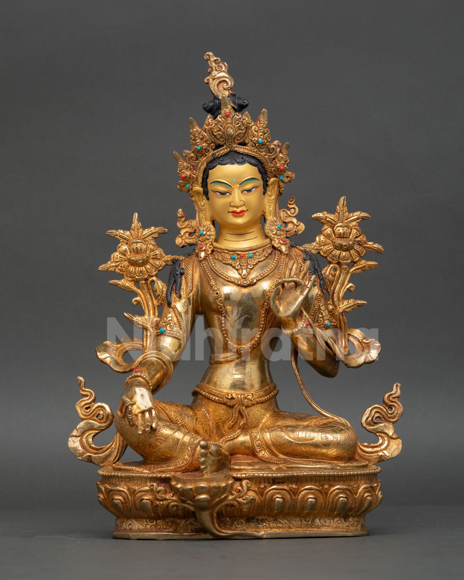 Handcrafted Green Tara statue from Nepal with gold-painted face and sacred jewelry.