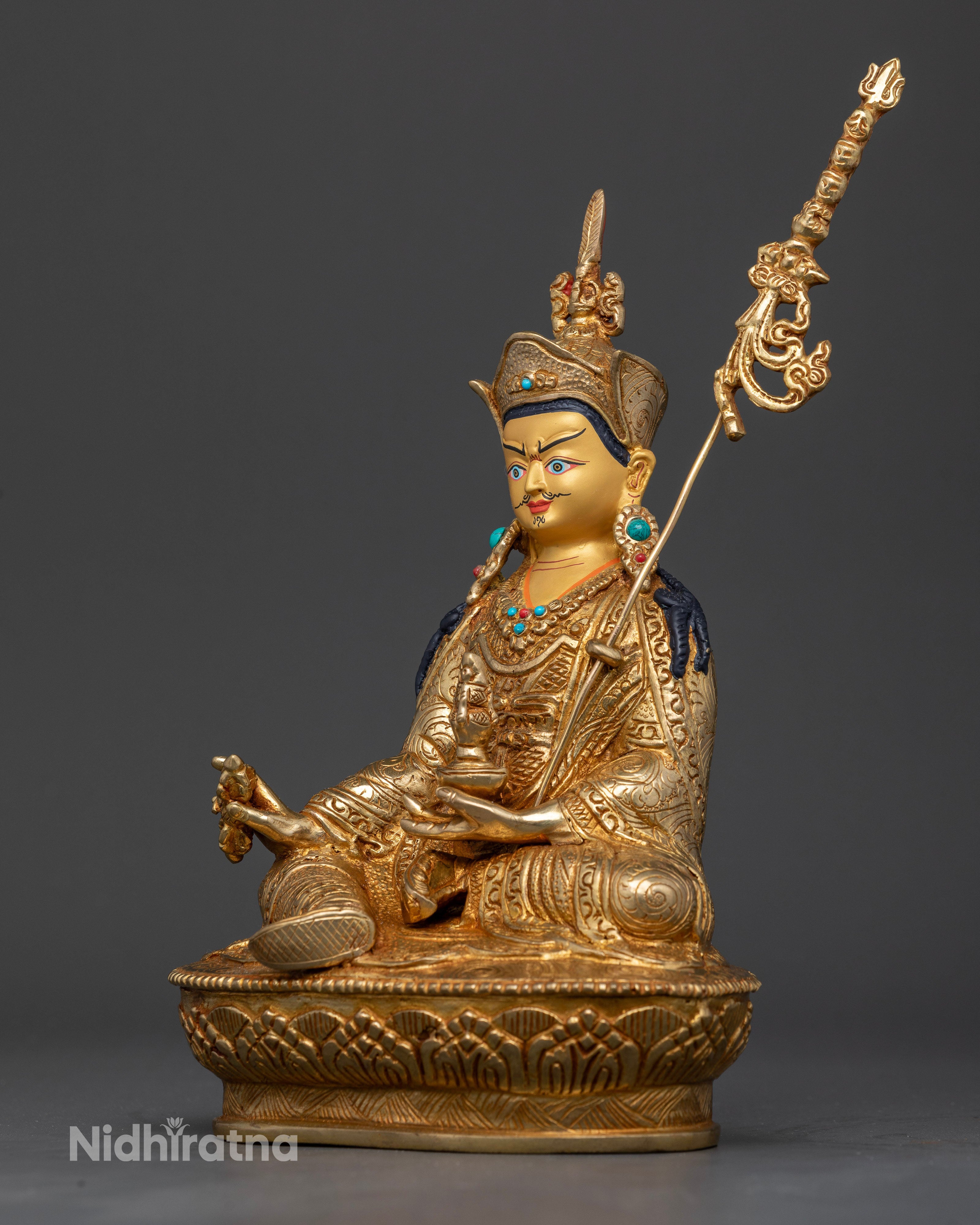 Handcrafted Guru Rinpoche statue with royal garments and floral motifs.