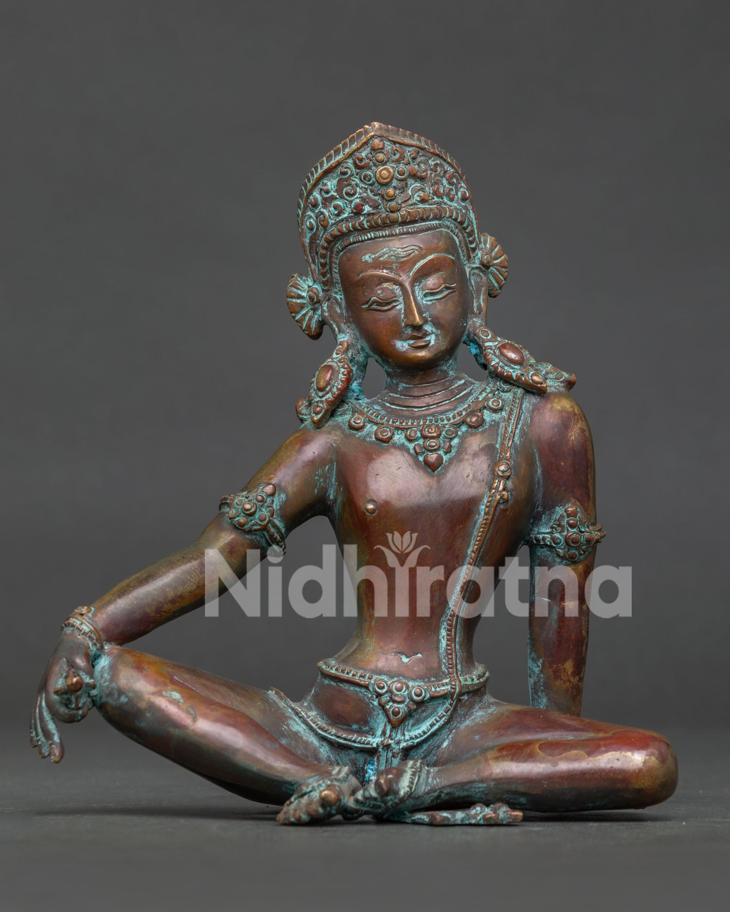 Handcrafted Indra statue in antique oxidized copper seated with ornate crown front view.