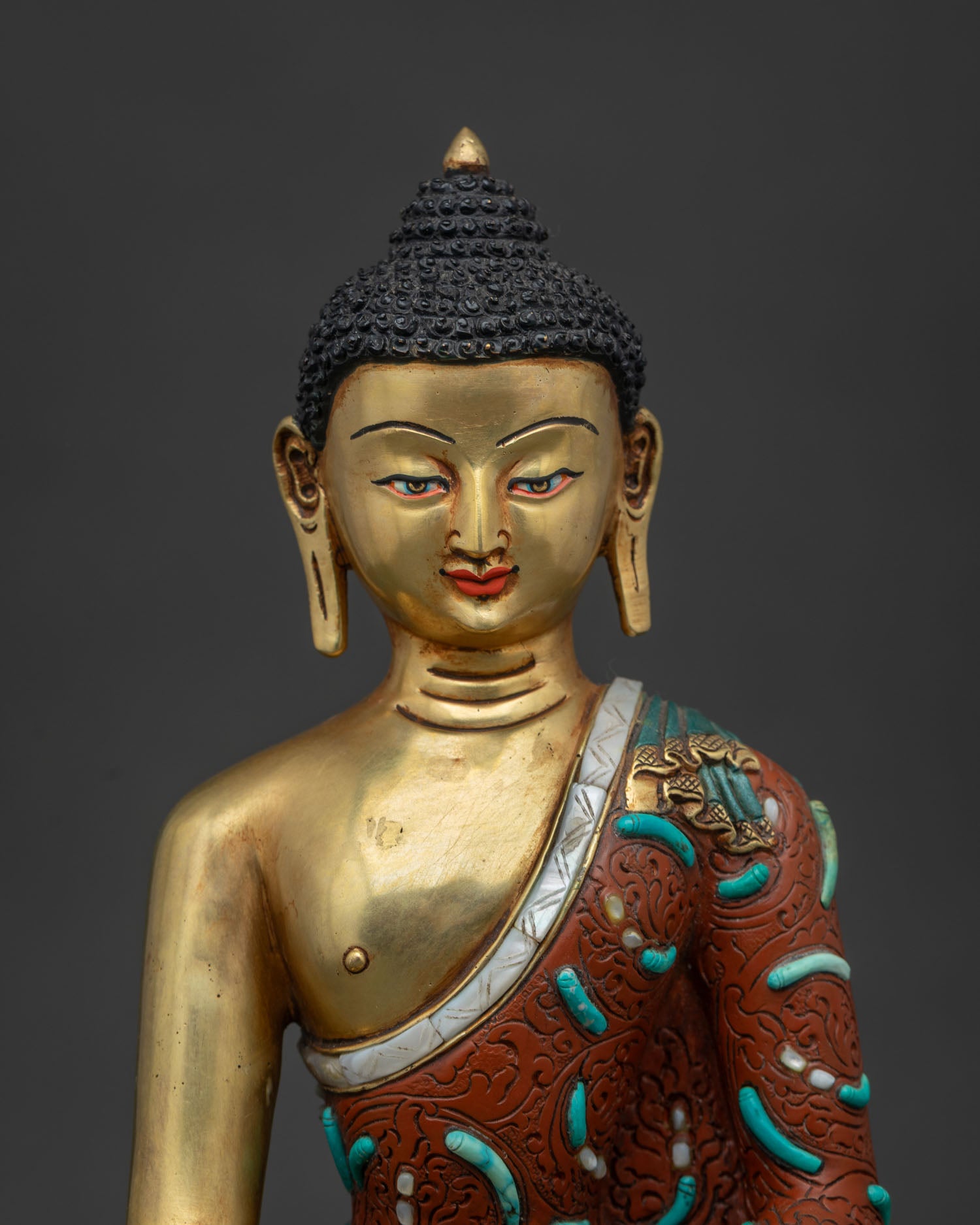 Handcrafted Shakyamuni Buddha copper statue with turquoise inlays and crimson robe detail Newari art
