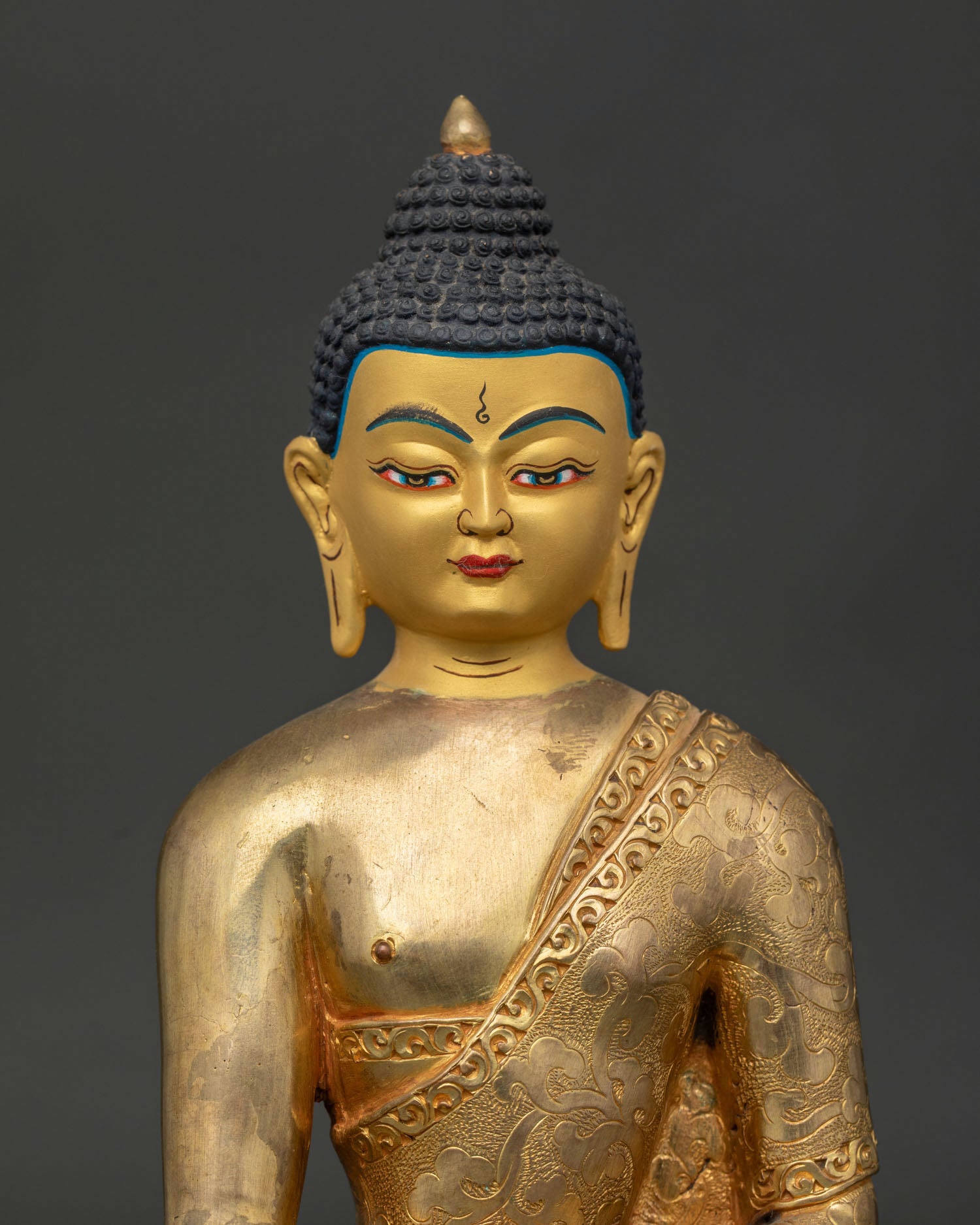 Handcrafted shakyamuni buddha statue from patan nepal with gold painted face.