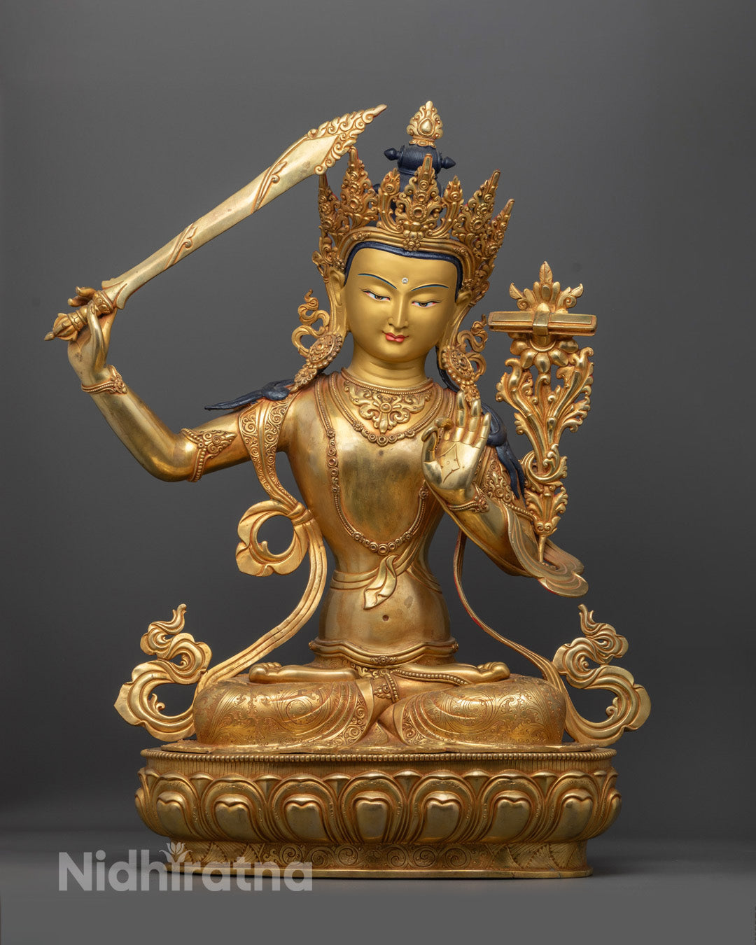 handcrafted Manjushri Buddha sculpture with gold-gilded face, vibrant acrylic colors, and intricate crown, robe, and jewelry carvings.