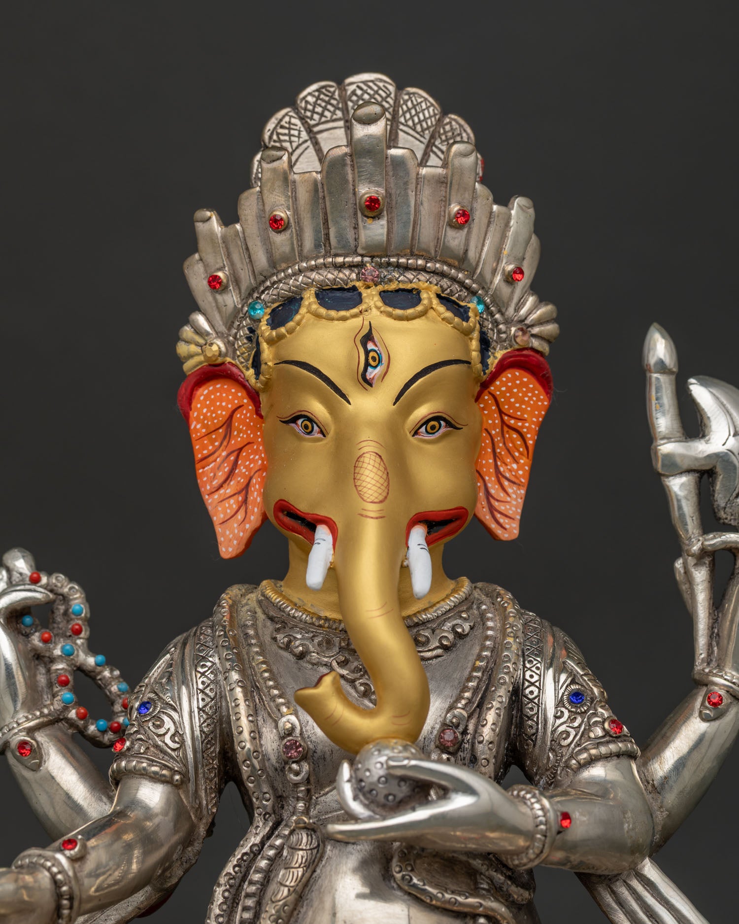 Handcrafted Ganesh idol close-up showing silver-plated copper with 24K gold face detail