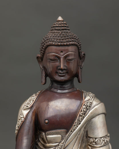 Handmade Shakyamuni Buddha statue from Nepal with silver plated monk robe close up.