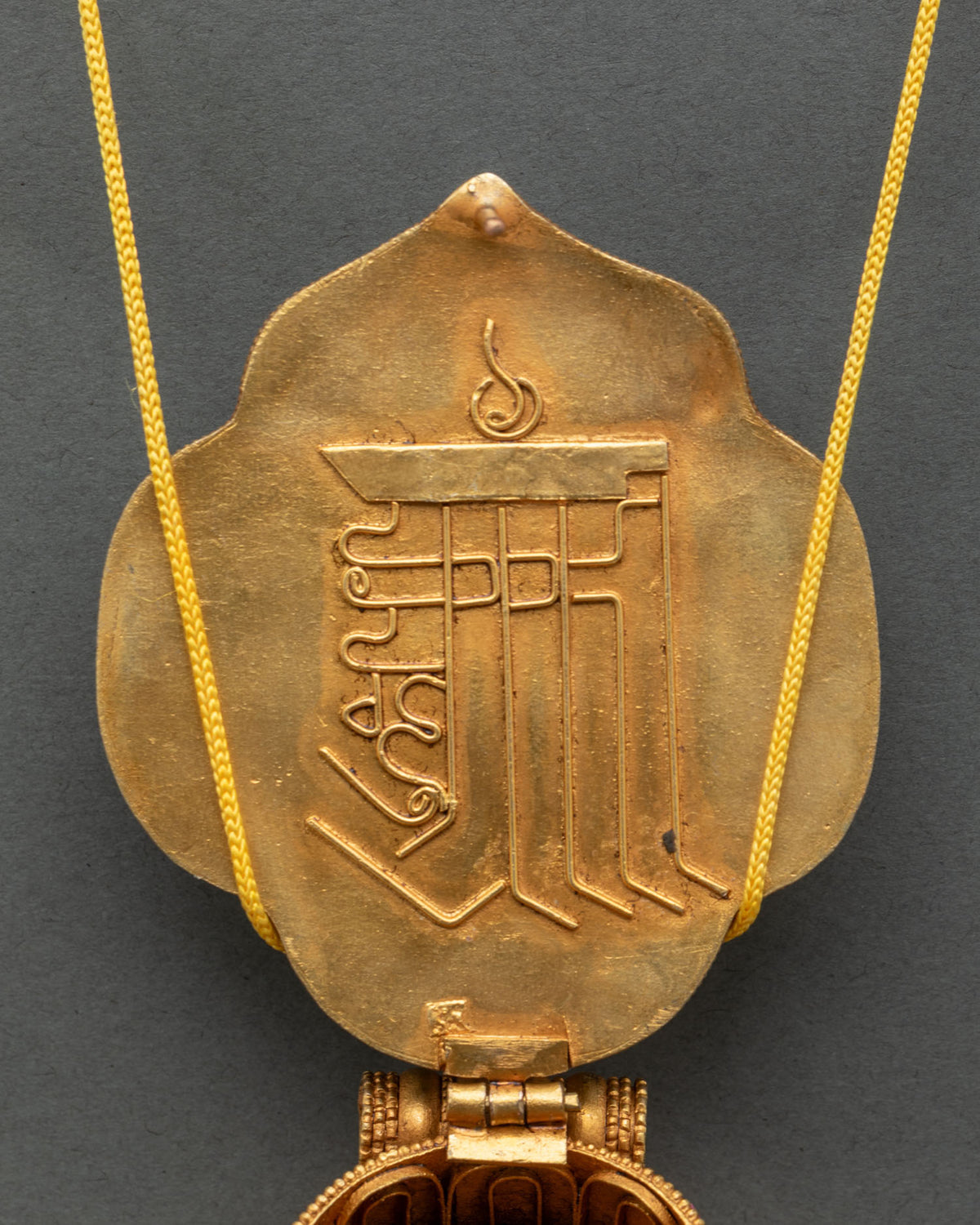 Handmade Tibetan Vajrapani ghau locket on golden cord, a protection amulet pendant from Nepal