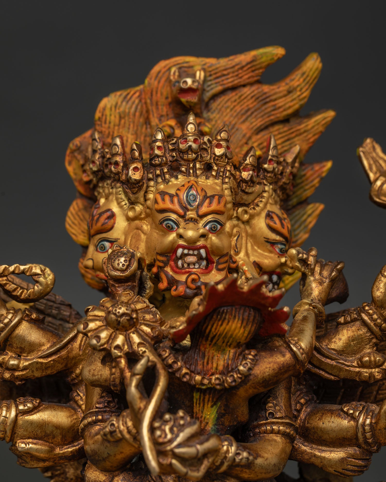 Hayagriva Statue Close Up with Three Fierce Faces Gold Painted Face and Ornate Jewelry.