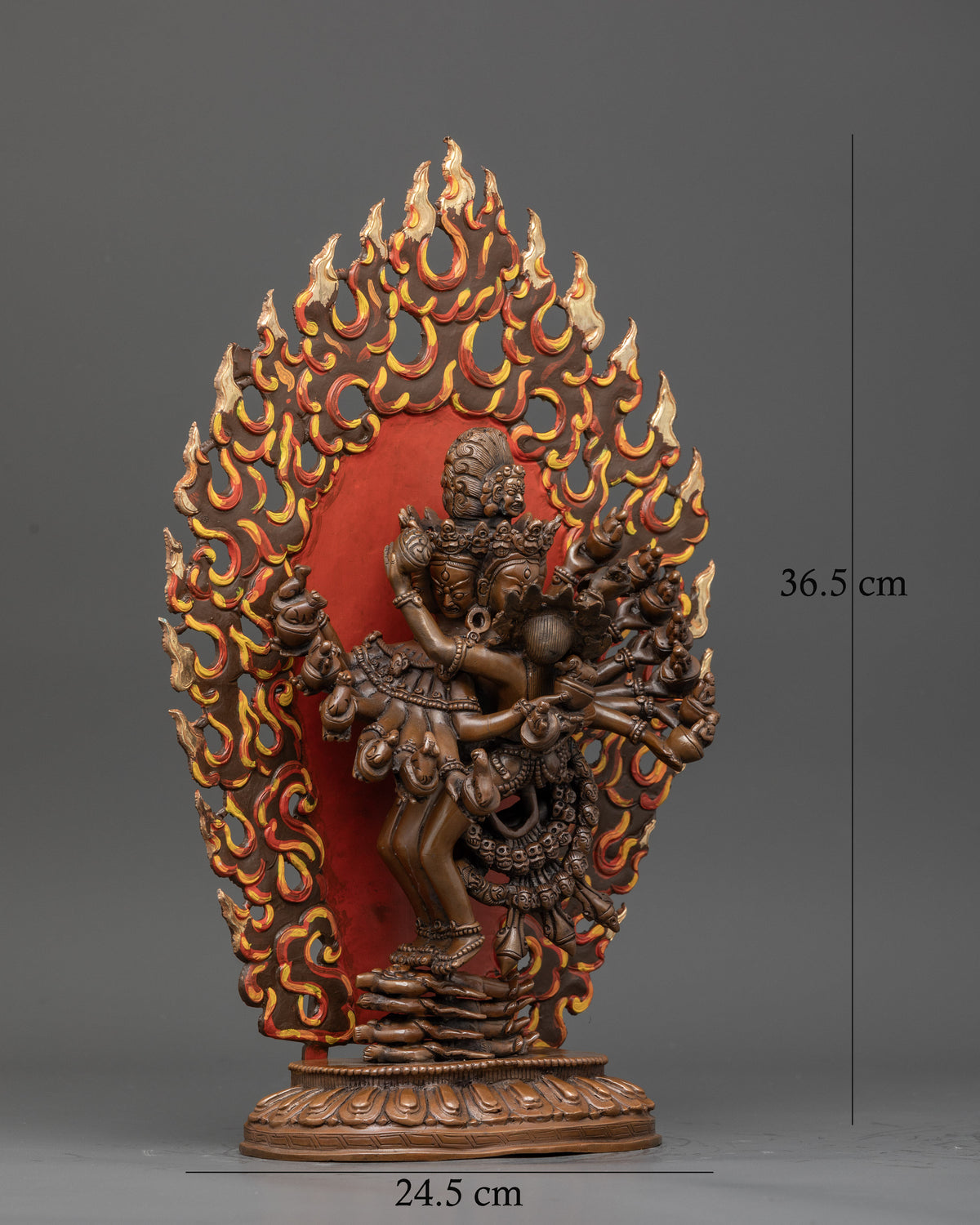 Hevajra statue with multiple heads and sixteen arms holding sacred ritual objects.