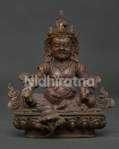 Himalayan Dzambhala statue with lotus base mongoose and citron fruit symbols.