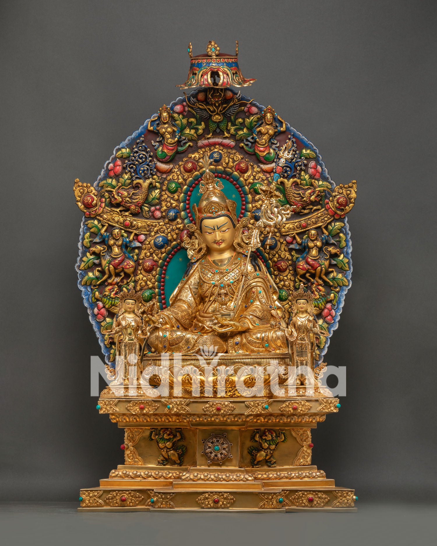 Large Guru Rinpoche statue seated in ornate gold-gilded throne with colorful aureole