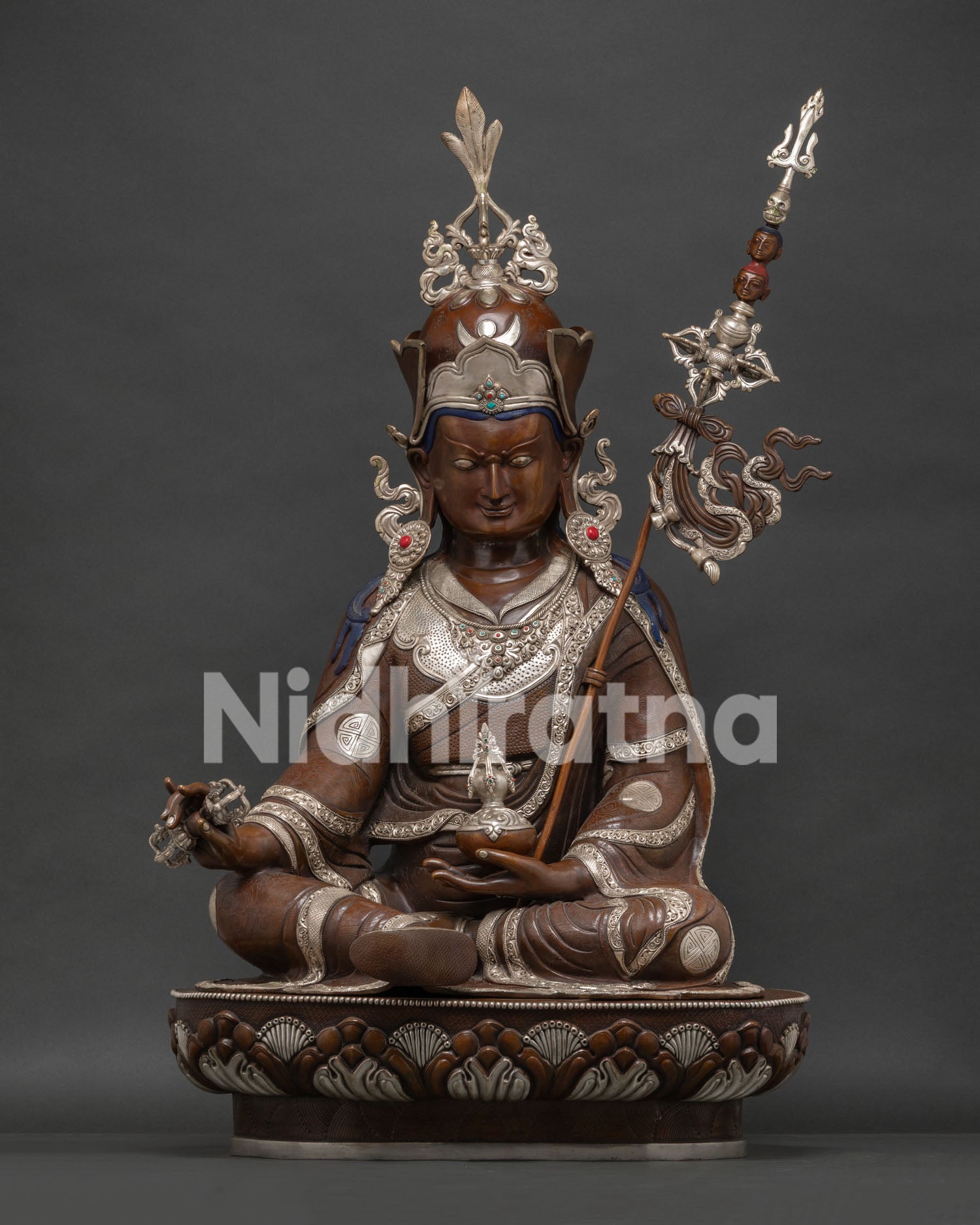 Large Guru Rinpoche statue with silver plating and oxidized copper finish on lotus throne.