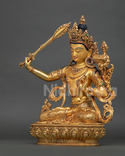 Left view side: left profile Manjushri statue Himalayan Buddhist art gold gilded robes intricate carvings
