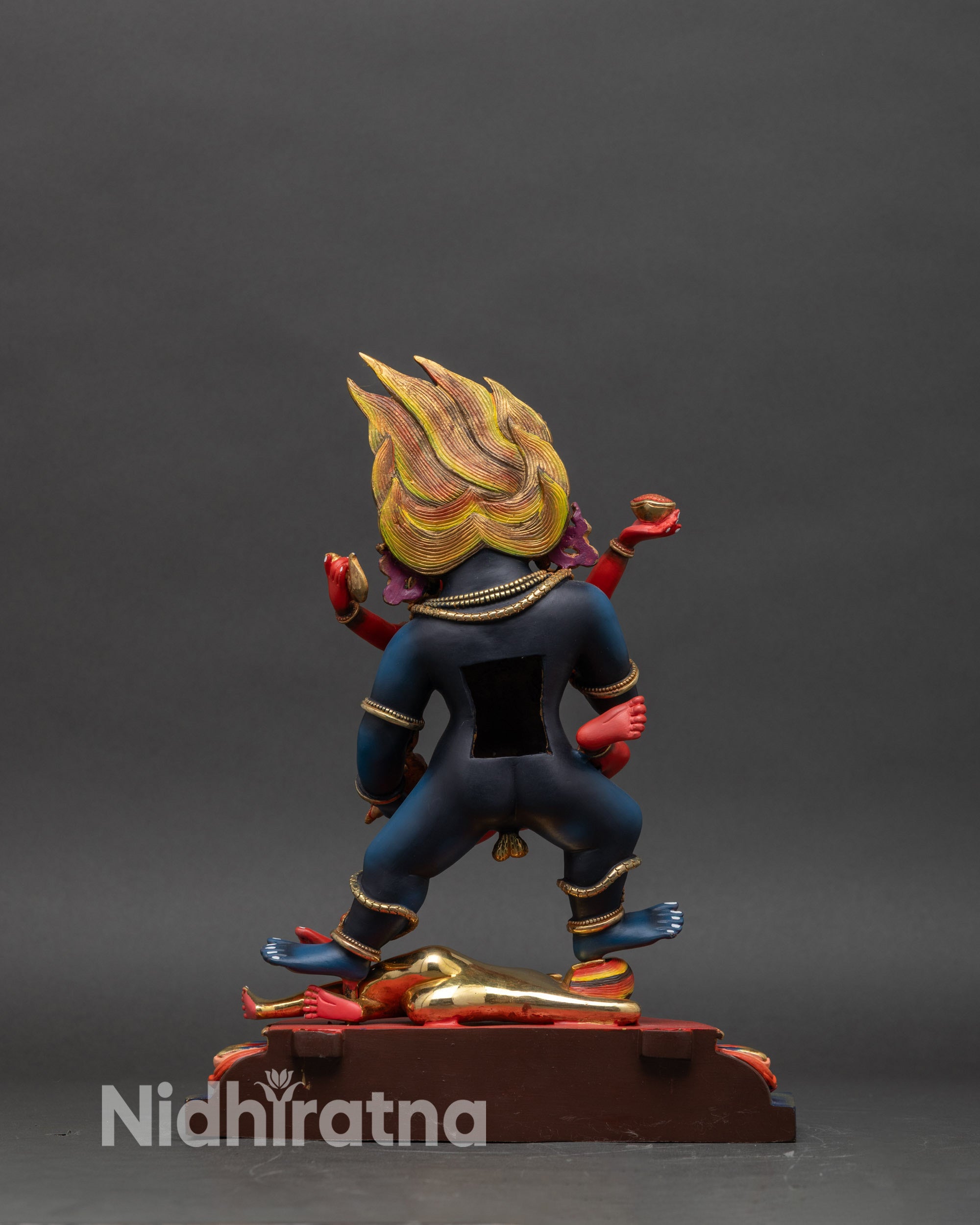 Left profile of Black Dzambhala Yab Yum statue with halo and colorful Buddhist details