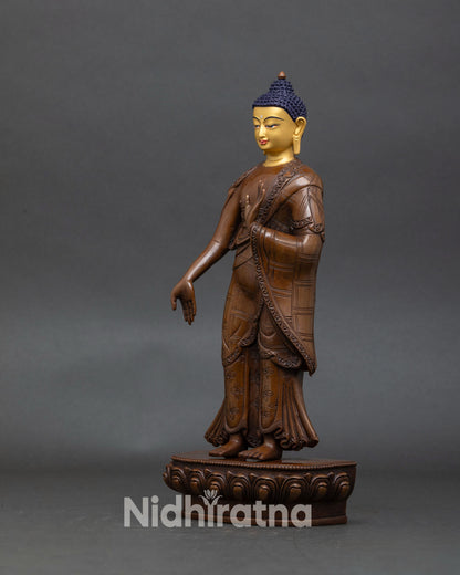 left profile of dipankara buddha standing statue with oxidized copper and gold face