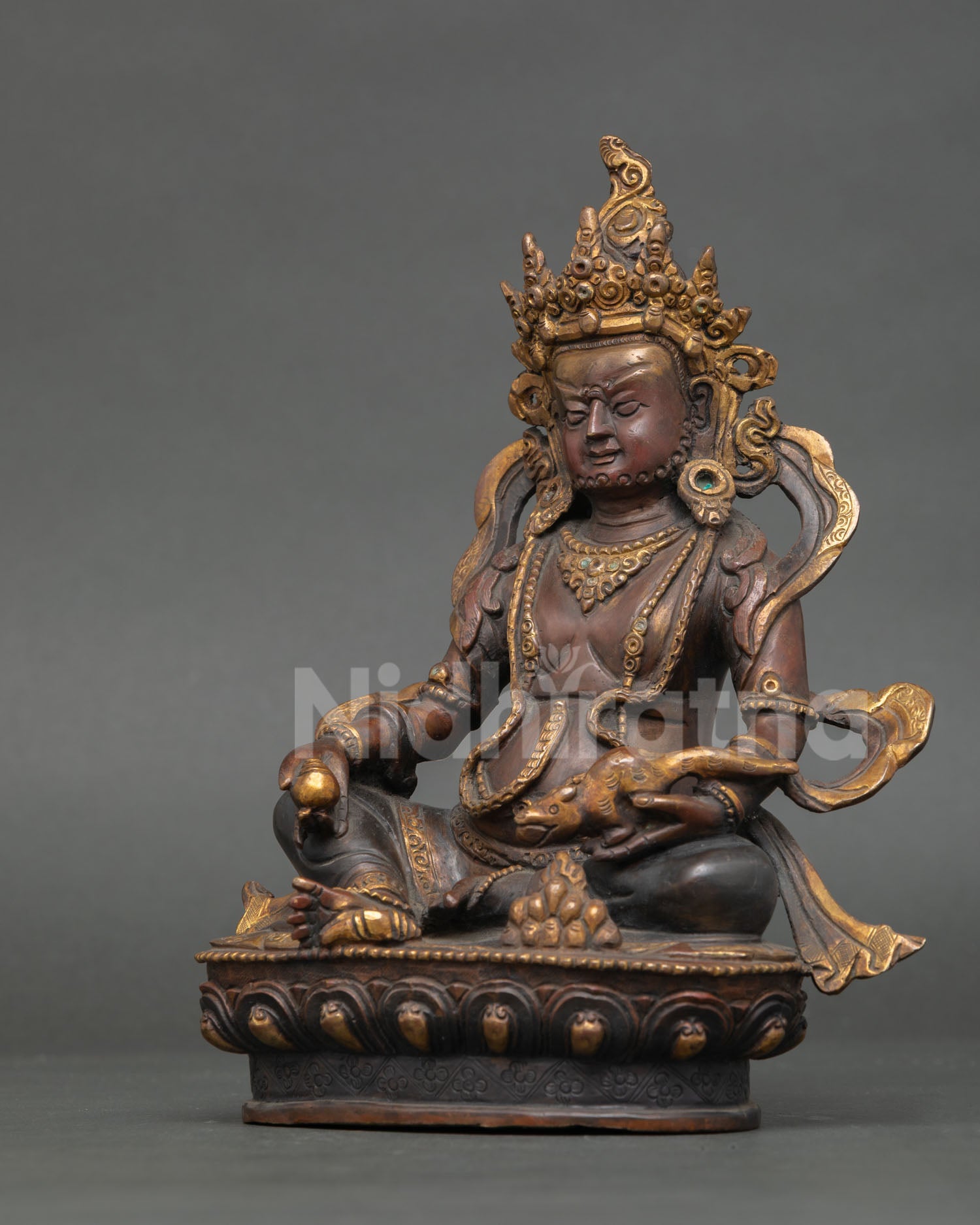 left profile of oxidized copper dzambhala sculpture with sacred buddhist details