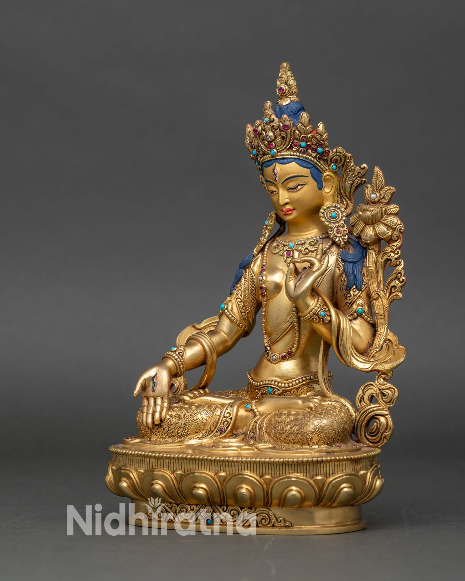 Left profile of White Tara statue, seven-eyed goddess with gold and gemstone details