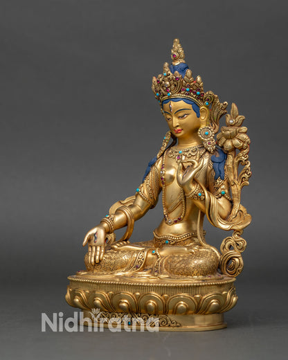 Left profile of White Tara statue, seven-eyed goddess with gold and gemstone details
