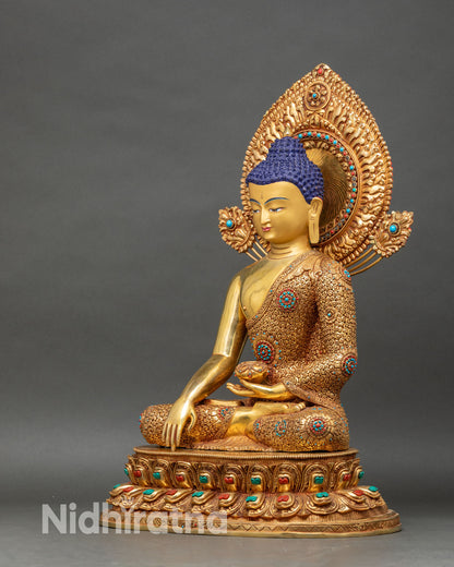 Left profile of Shakyamuni Buddha statue, copper and gold with detailed ceremonial robes