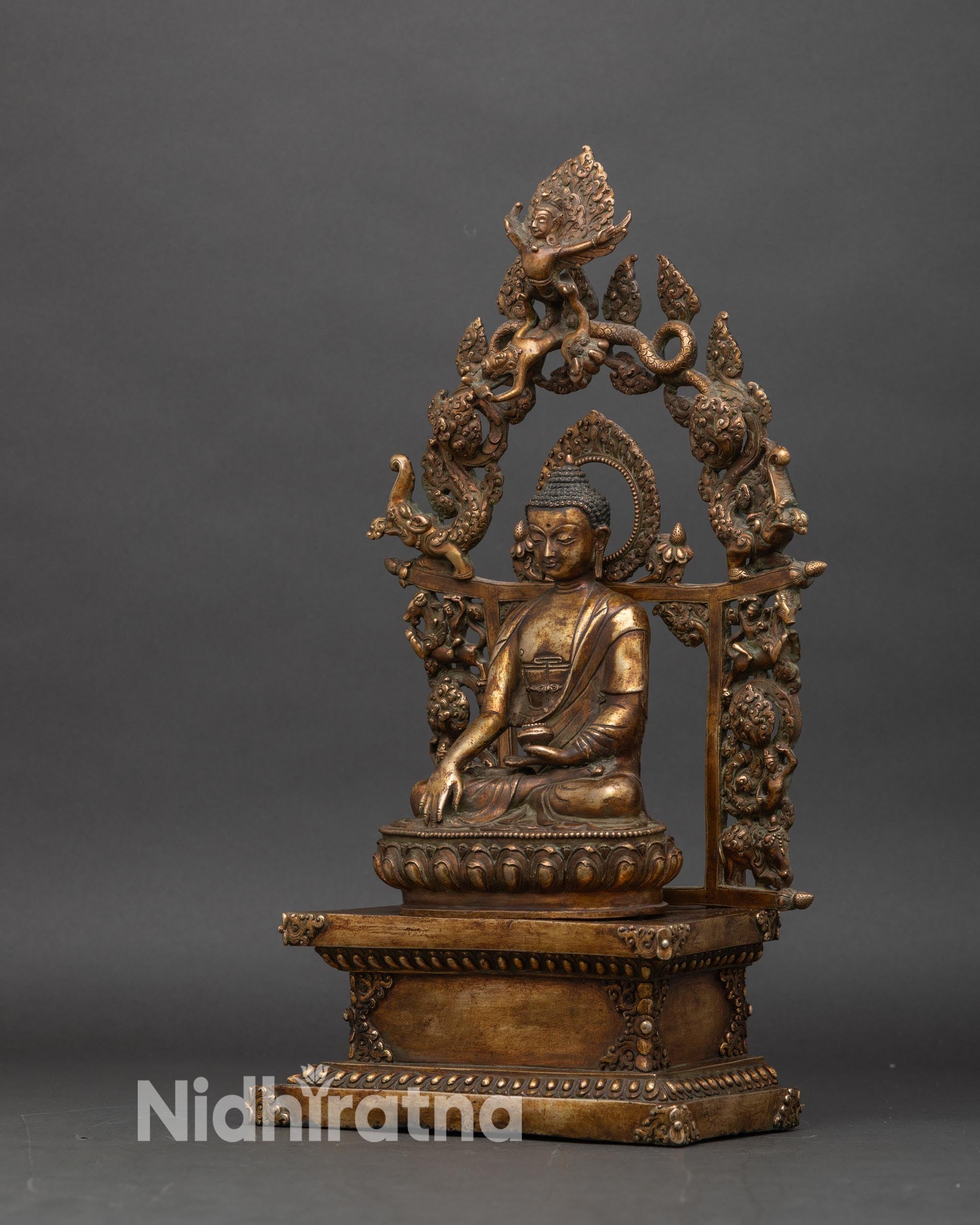 Left profile of Shakyamuni Buddha statue, lotus pedestal and floral halo details