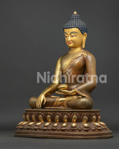 Left profile view of half gold fire-gilded Buddha statue holding alms bowl