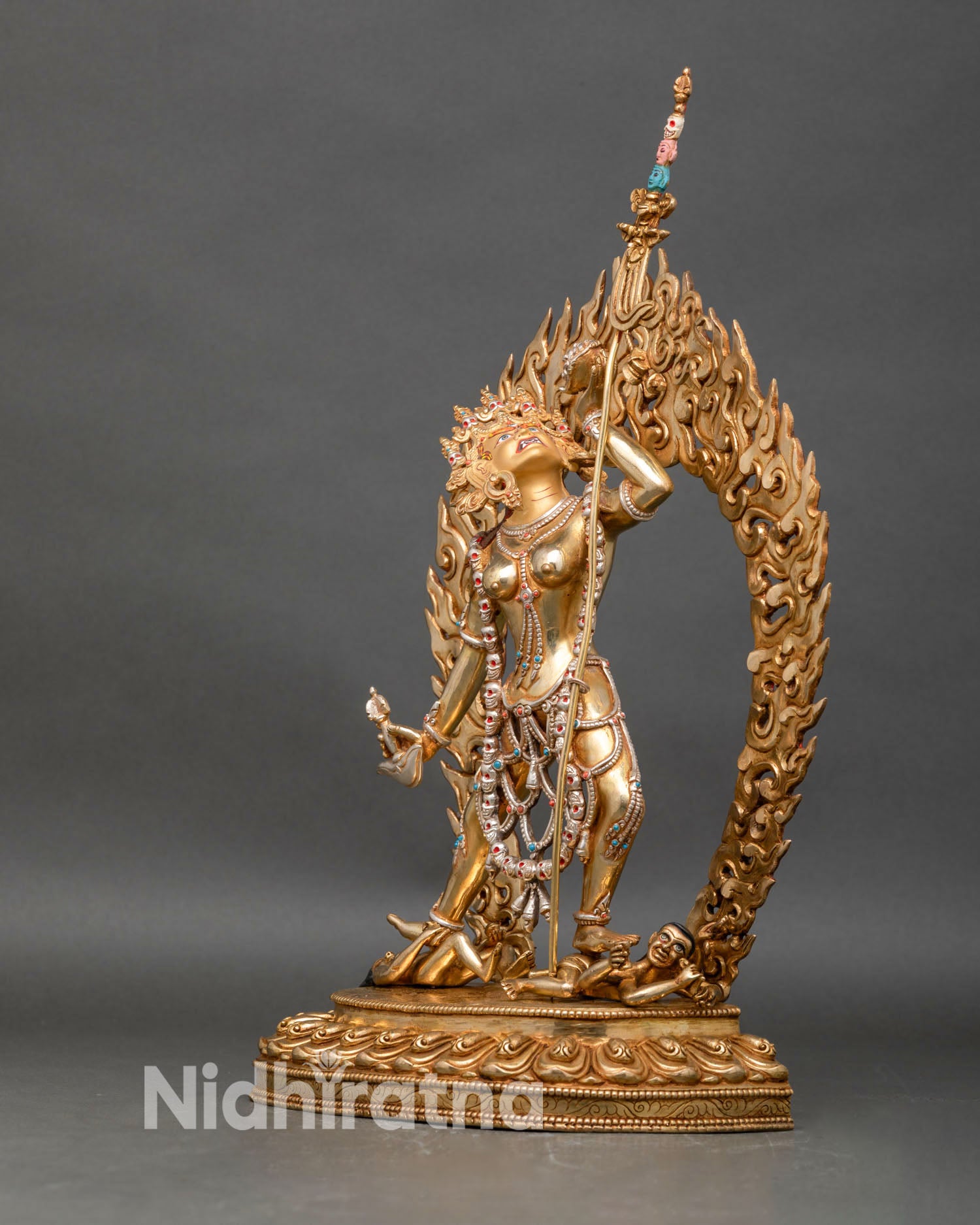 Left profile view of Vajrayogini statue, dynamic stance, gold gilding and gemstones
