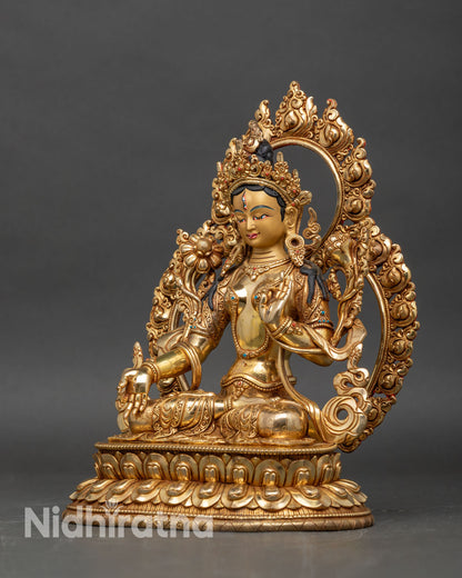Left profile of White Tara statue, lotus stem in hand and detailed jewelry visible