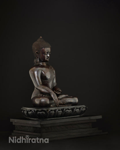 Left side profile of copper Shakyamuni Buddha statue seated on carved lotus pedestal