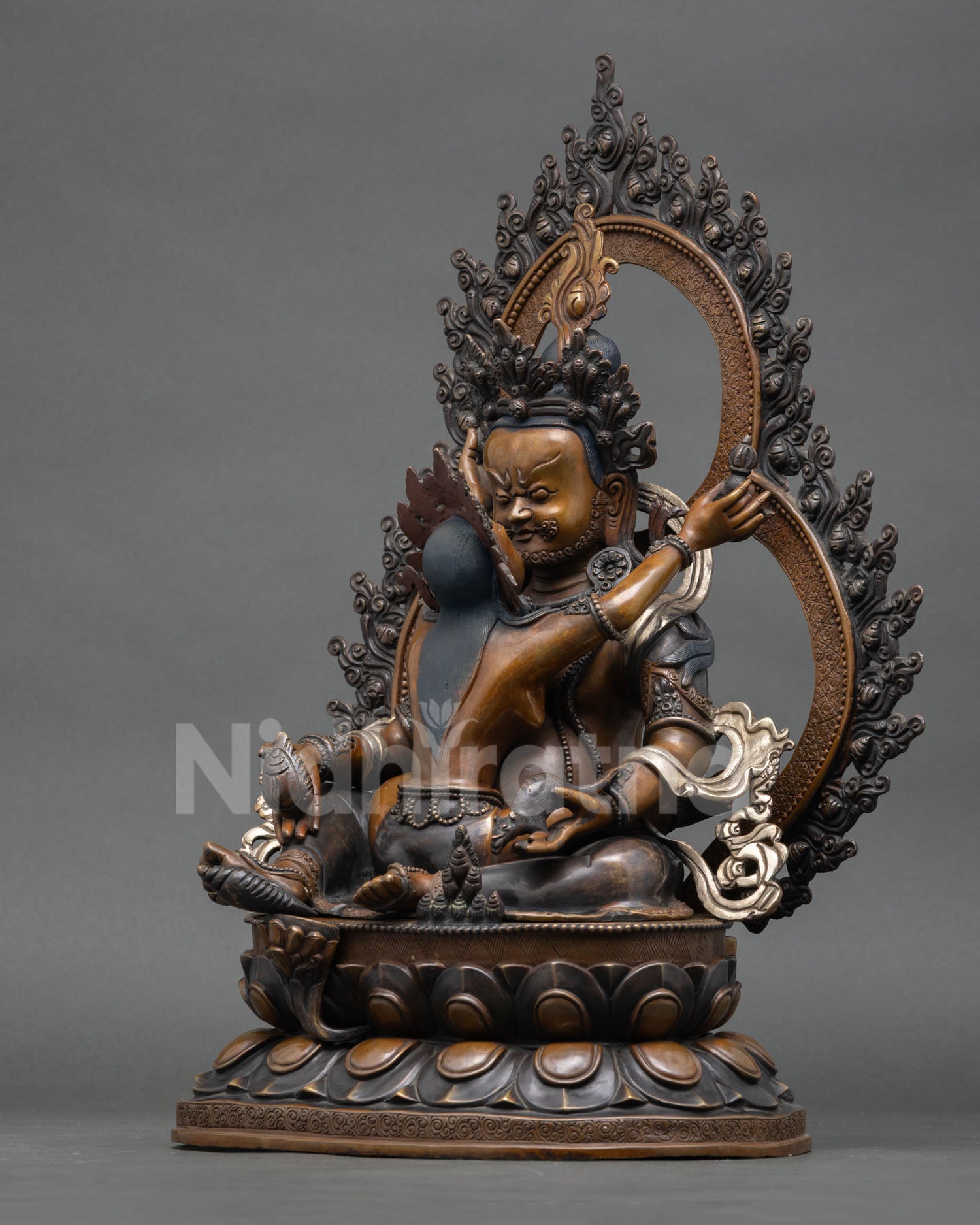 left side profile of green dzambhala statue seated on lotus throne with vasudhara