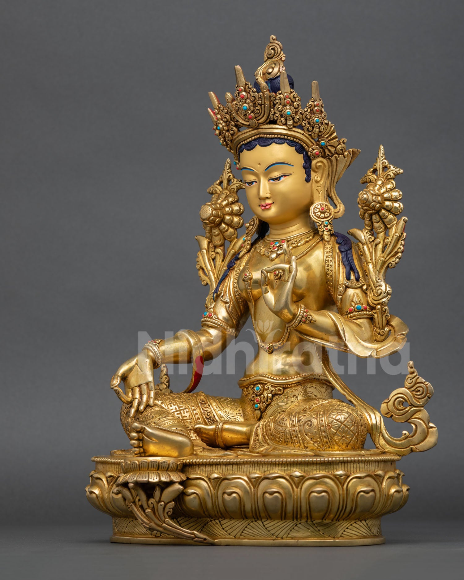 left side profile of green tara statue with intricate repousse carvings and gold finish