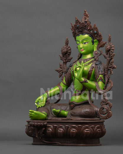 left side profile of green tara statue with oxidized copper body and floral scrollwork
