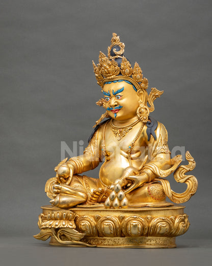 Left side profile view of gold gilded Yellow Dzambhala statue seated in royal ease posture.