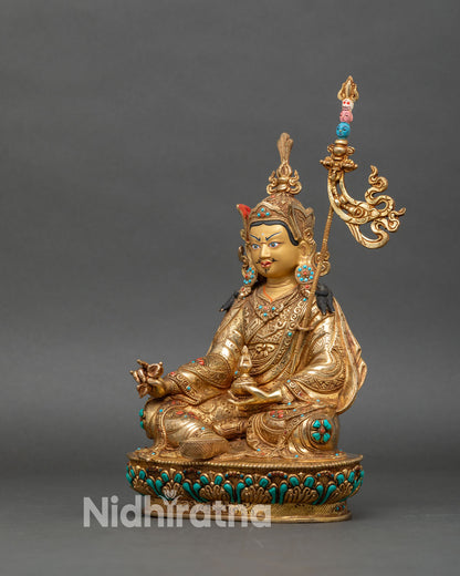 Left side view of Guru Rinpoche statue, gold-gilded copper with ornate garment details