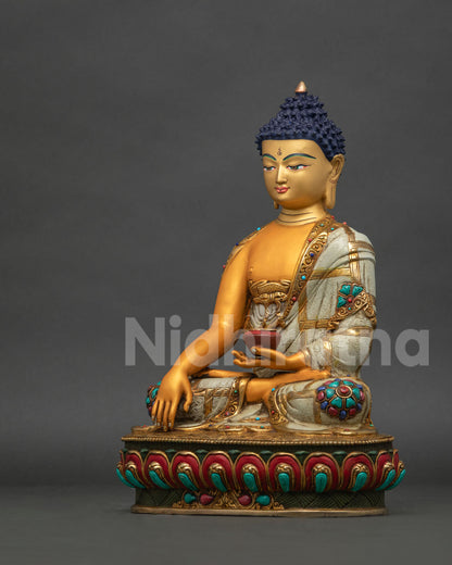 Left side view of Buddha statue with alms bowl and gold-trimmed acrylic robe
