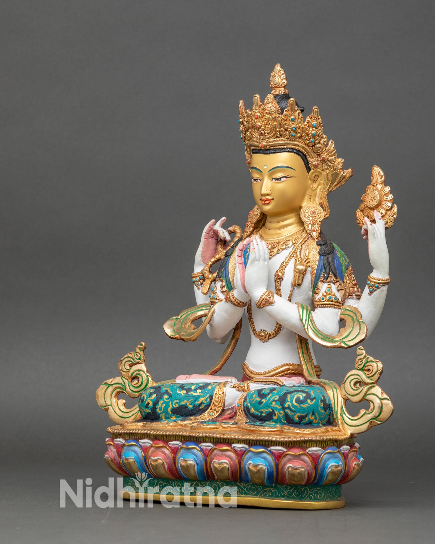 left side view of chenrezig statue showing four arms and gold-brushed jewelry