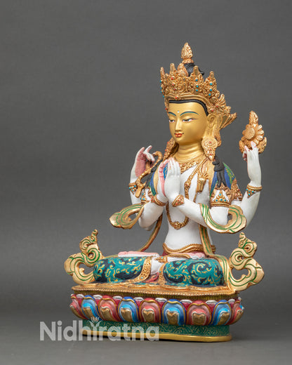 left side view of chenrezig statue showing four arms and gold-brushed jewelry