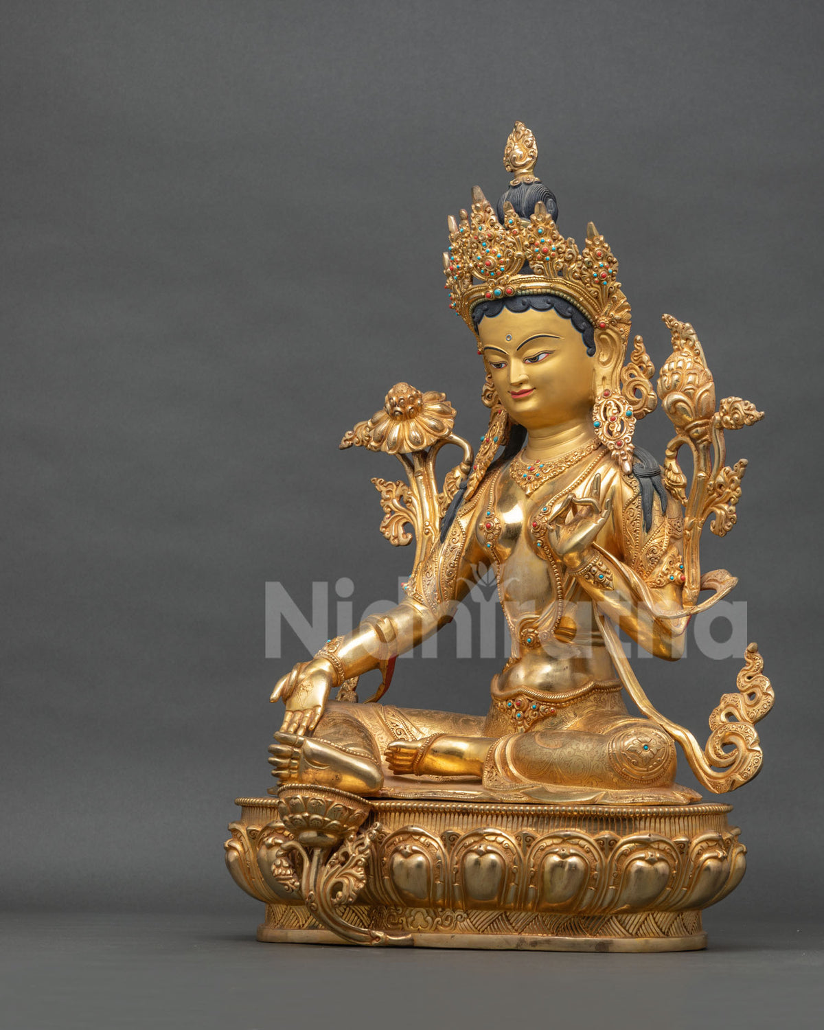 Left side view of copper Green Tara statue with gold fire-gilding on lotus throne