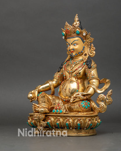Left side view of Dzambhala statue showing layered robes and lotus base