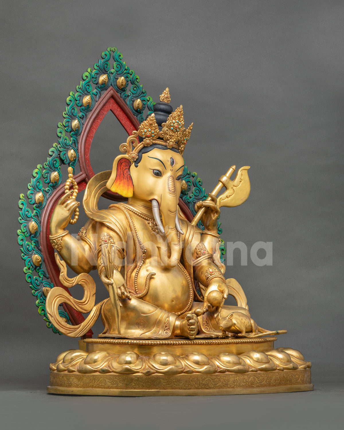 Left side view of gold fire-gilded Four-armed Ganesh statue seated on a lotus pedestal with halo