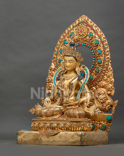 Left side view of gold fire-gilded Vajrasattva statue with vajra, bell and repoussé detailing