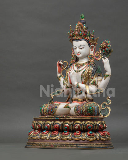 Left side view of gold gilded Chenrezig statue on lotus pedestal