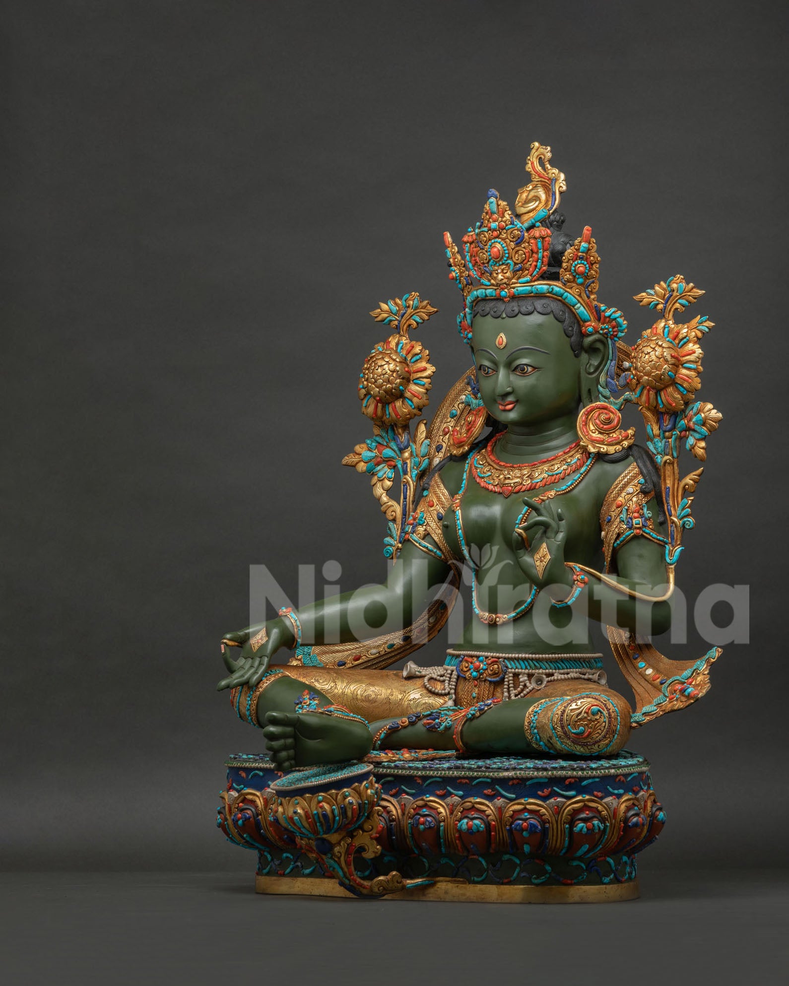 Left side view of Green Tara Buddhist statue showing Abhaya mudra hand gesture and copper carving.