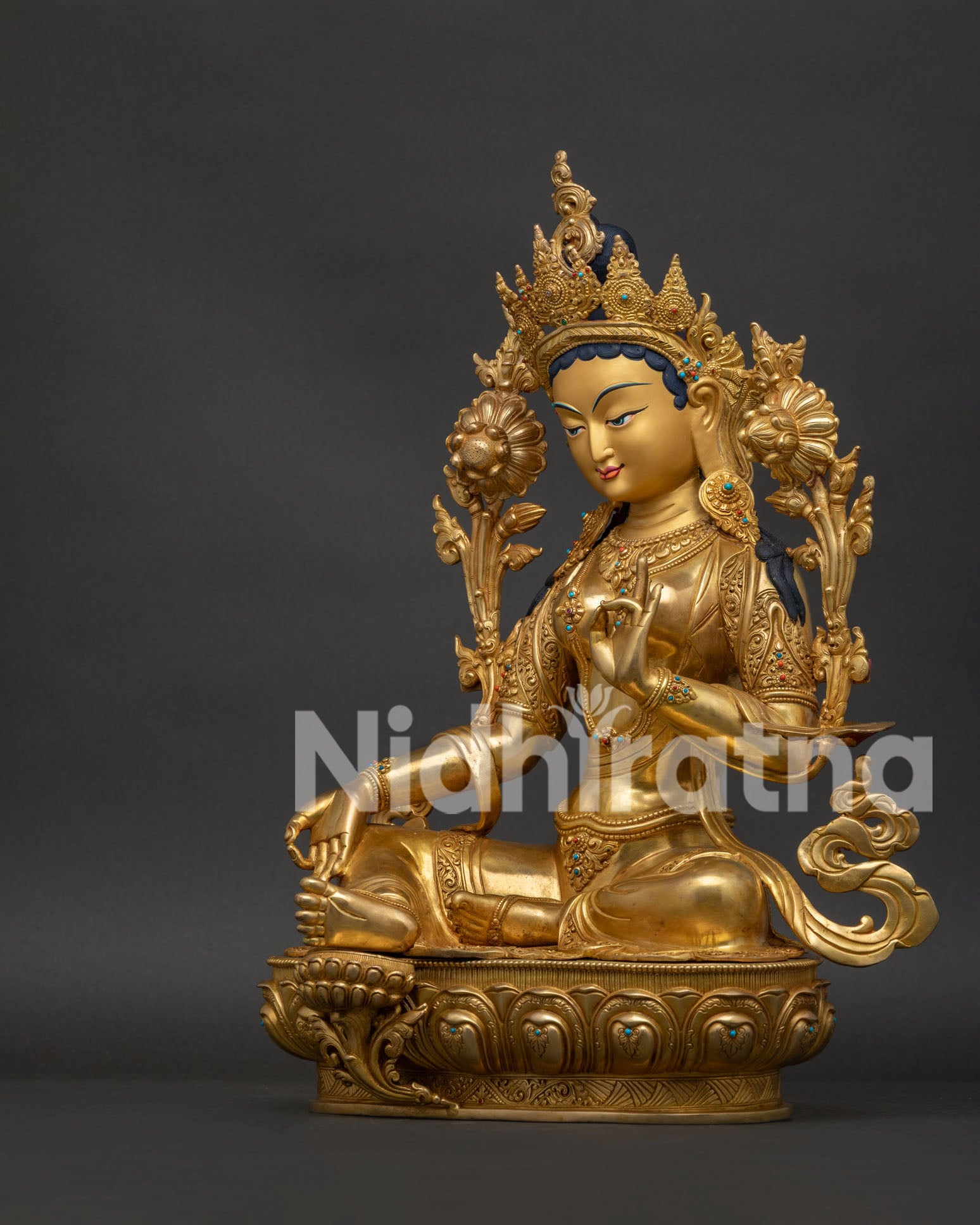 Left side view of Green Tara goddess sculpture showing lotus stems and gilded finish