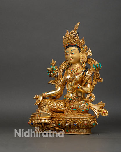 left side view of green tara statue, lotus seat and intricate jewelry with gold fire-gilding