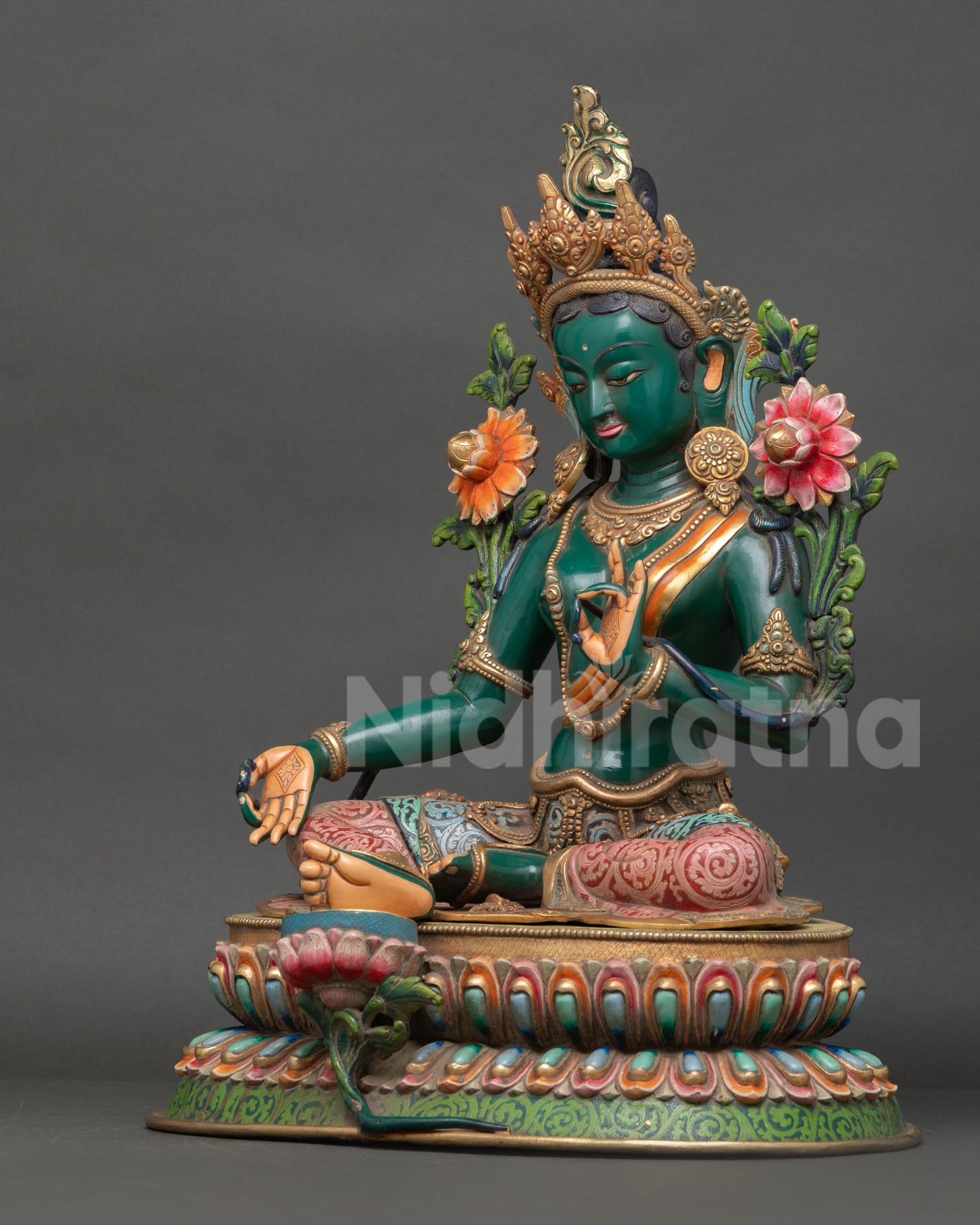 Left side view of Green Tara statue showing intricate carving, gold details and meditative posture