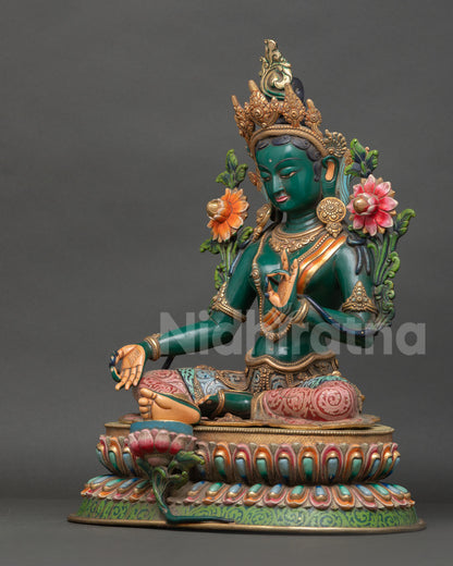 Left side view of Green Tara statue showing intricate carving, gold details and meditative posture