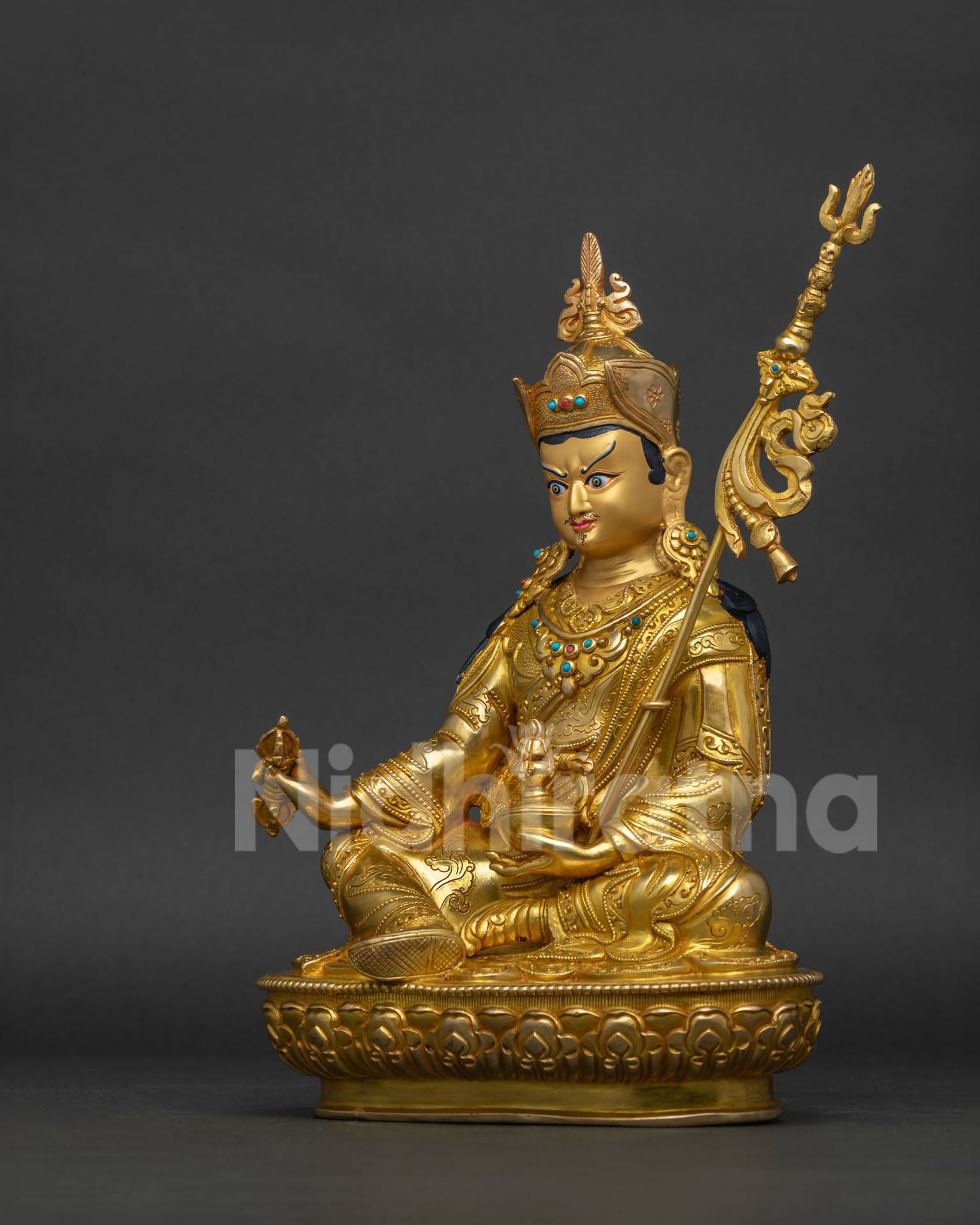 Left side view of Guru Rinpoche statue showcasing intricate copper carving, gold gilding