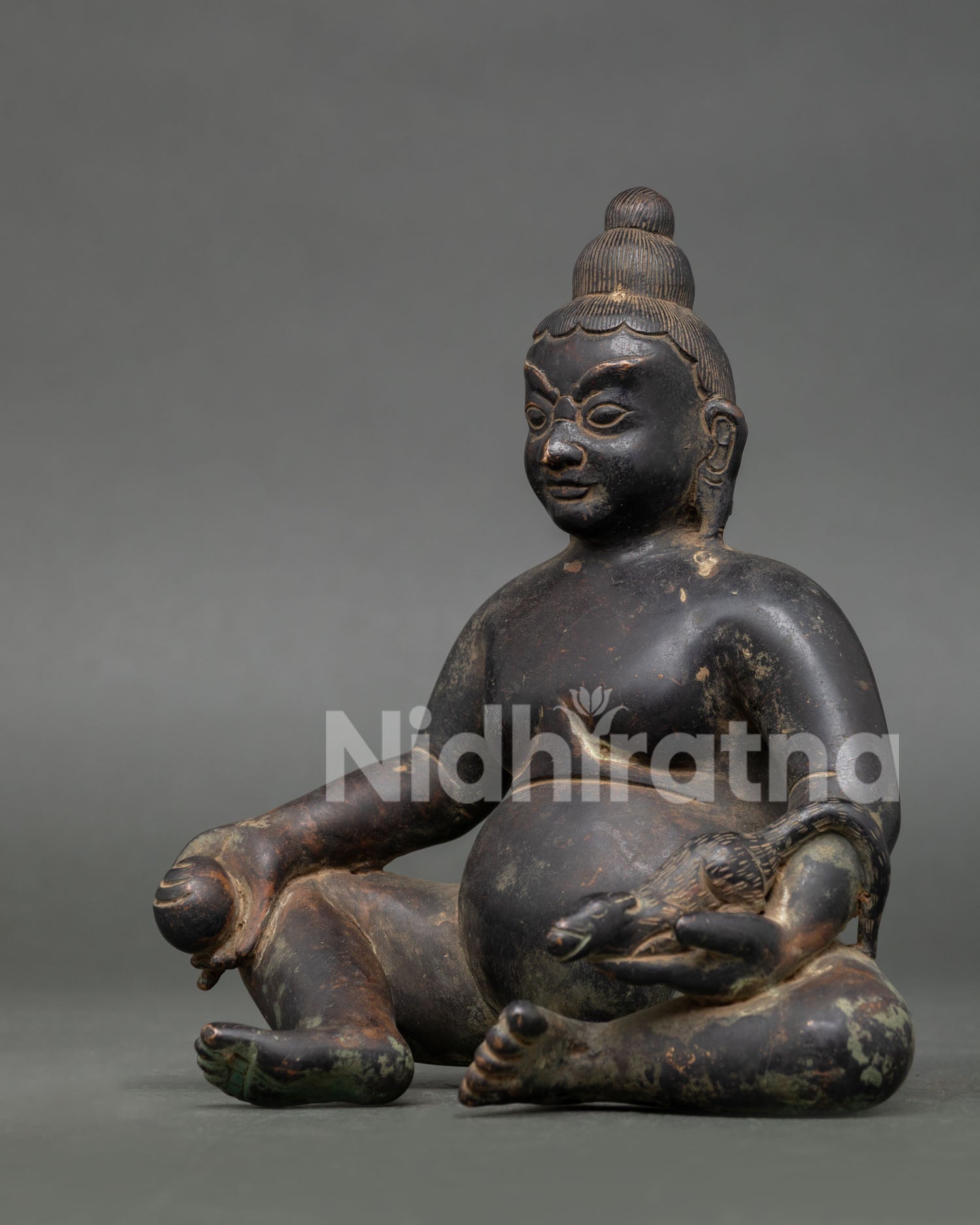 left side view of handcrafted dzambhala statue with antique oxidized copper finish