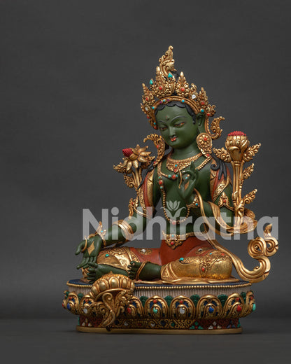 Left side view of handmade Green Tara Buddhist statue showing lotus throne details.
